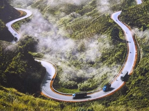 Những đoạn dốc quanh co uốn khúc ôm lấy những ngọn núi tai mèo kỳ vĩ, ngang qua những triền ngô xanh mướt và những nếp nhà mộc mạc là cảnh trí thiên nhiên thơ mộng khiến bất cứ ai cũng mong muốn được trải nghiệm một lần trong đời. Đây là điểm thu hút khách du lịch của Hà Giang khi có thiên nhiên rất thơ mộng, hùng vĩ và hiểm trở. (Ảnh: VOH)