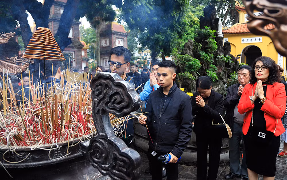 Nhiều người dân ở Hà Nội đến chùa Trấn Quốc vào mùng 1 Tết để cầu bình an và mọi điều tốt đẹp cho gia đình trong năm mới. Ảnh: hanoimoi.