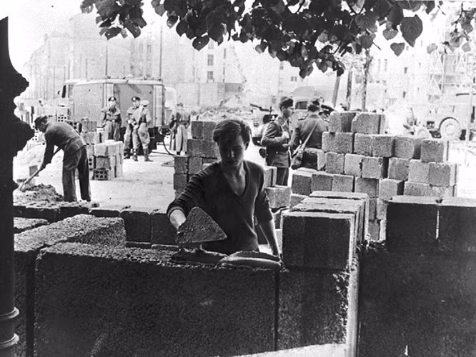 Ngày 13/8/1961, bức tường Berlin bắt đầu được dựng lên. Ảnh: Một công nhân Đông Đức đặt những khối gạch đầu tiên của Bức tường Berlin.