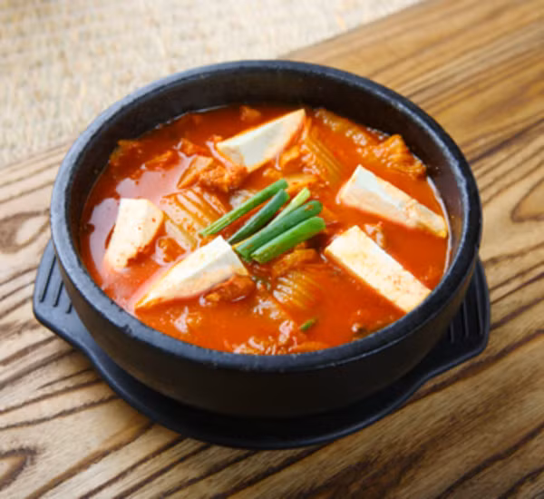 Nước dùng cho món lẩu kim chi ngon nhất là nước dùng gà. Phần gốc kim chi cải thảo cho vào nấu trong nước dùng, phần còn lại cắt khúc vừa ăn để nhúng. Các đồ nhúng bao gồm thịt ba chỉ, mực, cá, ghẹ, ngạo....Ảnh: Japan Centre.