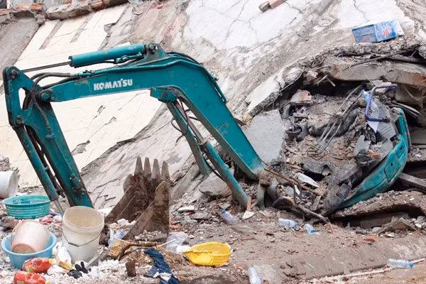 Chiếc máy xúc mini đang đào móng ngôi nhà số 41 cũng bị đè bẹp.