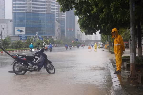 Trong khi đó, trên một số tuyến đường như đường Dương Đình Nghệ, Phạm Hùng... các công nhân thoát nước Hà Nội túc trực liên tục để giải thoát nước, tránh xảy ra ngập úng nặng. Ảnh công nhân thoát nước làm việc trên đường Dương Đình Nghệ.