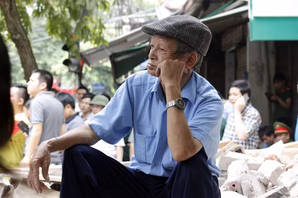 Cụ ông lớn tuổi chăm chú theo dõi công tác tìm kiếm các nạn nhân.
