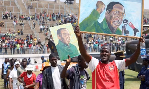Người ủng hộ diễu hành mang theo ảnh của ông Mugabe. Ảnh: Sky News.