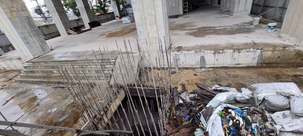 Bê tông cốt thép bắt đầu hoen gỉ, xung quanh là rác thải.