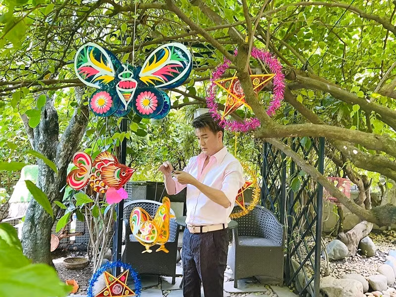 Nam ca sĩ tự tay treo đèn Trung thu lên cây cối trong khu vườn năm 2019. Ảnh: FBNV