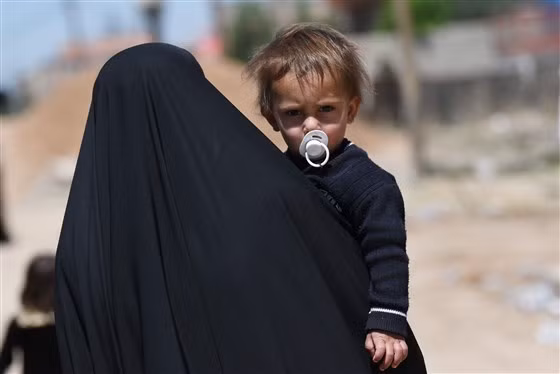 Một phụ nữ Iraq bế một bé trai trên đường phố Mosul, Iraq tháng 4.2017.