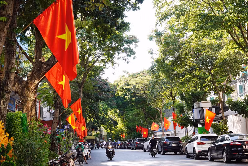 Sắc vàng nắng thu Hà Nội hòa với sắc đỏ của cờ, phướn làm những con phố Thủ đô thêm rực rỡ.