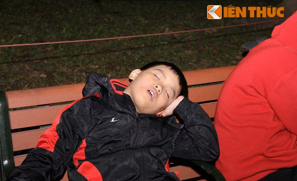 Do tới nhận chỗ từ rất sớm, em bé này phải tranh thủ ngủ một giấc chờ giao thừa.
