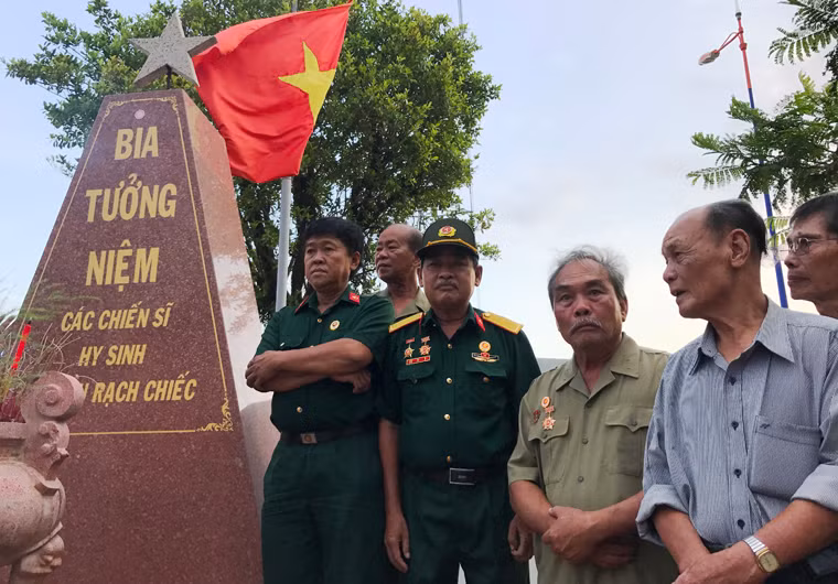 Những người lính năm xưa bên mộ đồng đội của mình.