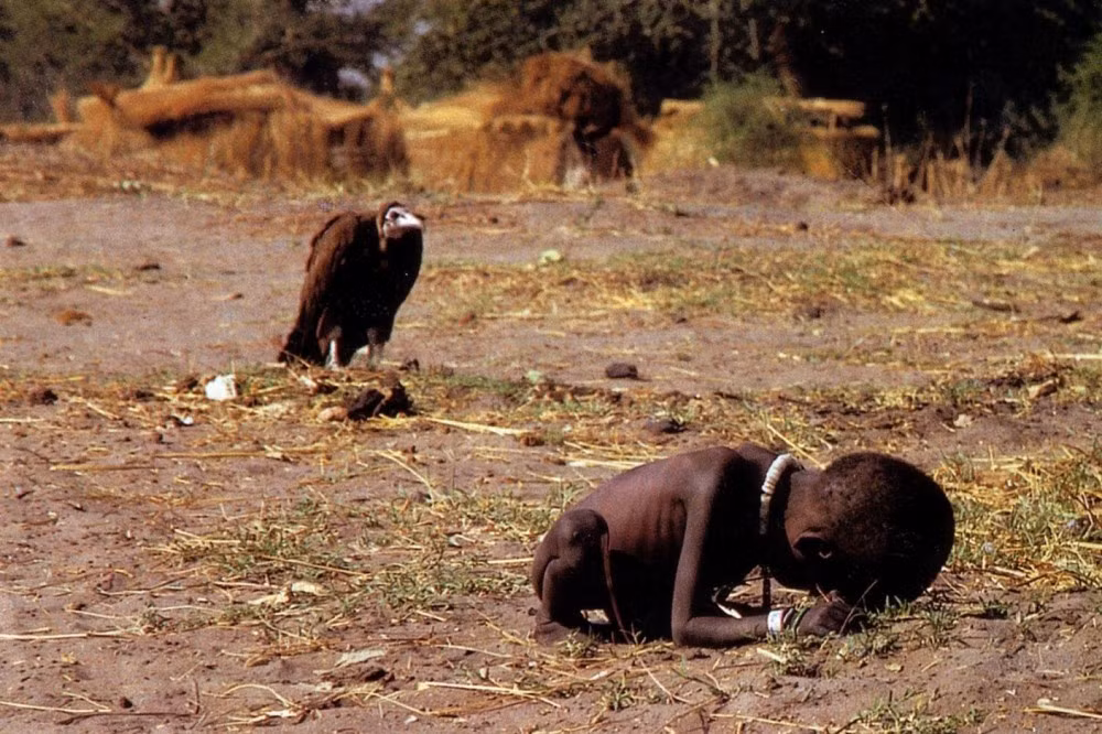 Trong chuyến đi đến Sudan năm 1993, nhiếp ảnh gia Nam Phi Kevin Carter đã chụp được bức ảnh gây sốc cả thế giới mang tên "Kền kền chờ đợi". Bức ảnh đó ghi lại khoảnh khắc một bé gái gần như sắp chết đang cố lê mình tới một trung tâm cứu trợ. Khi nhiếp ảnh gia Carter chuẩn bị chụp ảnh em bé thì một con kền kền hạ cánh xuống gần đó và nó có mặt trong khuôn hình. Cho đến nay, số phận bé gái đó vẫn là một bí ẩn. Vài tháng sau khi giành giải thưởng Pulitzer với bức ảnh gây sốc trên, phóng viên ảnh Kevin Carter đã tự sát.