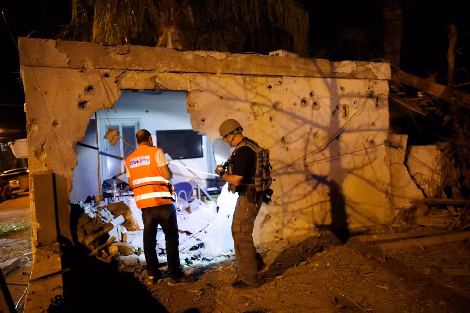 Các nhân viên an ninh Israel đang kiểm tra tình trạng hư hại của một ngôi nhà ở Ashkelon, Israel - thành phố hứng chịu nhiều đợt pháo kích nhất từ phía dải Gaza. Nguồn ảnh: BI.