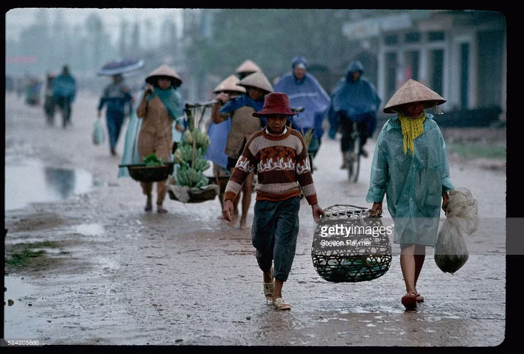 Người dân đưa hàng hóa ra chợ dưới trời mưa trên Quốc lộ 1 ở Quảng Trị.