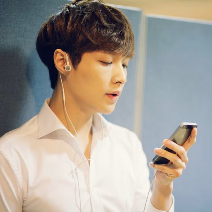 Thành viên khác của EXO - Lay say mê giải trí với chiếc iPhone 5S. Ảnh: Kdramasta.