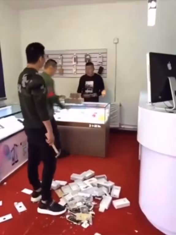 Muốn chứng tỏ mình là người có tiền, một thanh niên Trung Quốc đã "đập hộp" theo đúng nghĩa đen 10 chiếc iPhone mới sau khi thanh toán đủ số tiền cho chủ cửa hàng. Ảnh: Kwai.