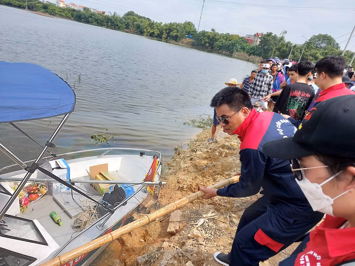 Đội cứu hộ được người dân cung cấp sào tre để hỗ trợ chuyển ca nô xuống nước.
