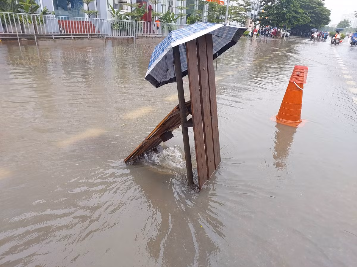 Nắp cống buộc phải tháo dời để xả nhanh nước mưa mưa ngập úng.