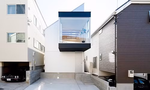 Ngôi nhà 2 tầng được thiết kế với bức tường rộng mở bằng chất liệu kính trên tầng 2.