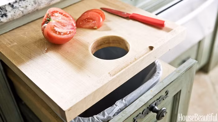 Một chiếc thớt có lỗ gắn liền với thùng rác giúp bạn không mất nhiều công đoạn để chuẩn bị và dọn dẹp vệ sinh khi sơ chế thức ăn.