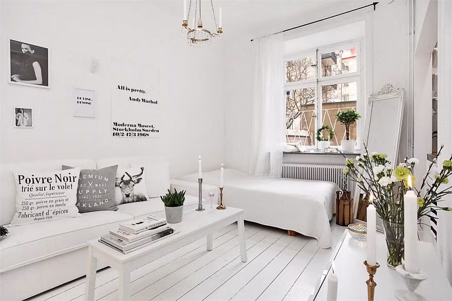 Cạnh sofa là chiếc giường đơn được phủ ga màu trắng.