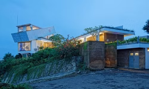 Ngôi biệt thự xinh xắn này được thiết kế bởi kiến trúc sư Budi Pradono, nằm trên một ngọn đồi nằm ở hòn đảo phía Indonesia của Bali. Và đặc biệt, ngôi biệt thự có một căn phòng nhỏ nằm nghiêng trên nóc nhà. Nằm ở vị trí cao nhất của ngôi nhà, căn phòng nhỏ này nằm ở góc 60 độ với trần nhà. Mặt ngoài được sơn trắng nhằm giảm nhiệt hấp thụ từ ánh nắng mặt trời. Các bức tường trong ngôi biệt thự được phủ bằng đất sét theo ý tưởng của nhà thiết kế và có độ dày đến 30 cm để ngăn thời tiết quá nóng hoặc quá lạnh.