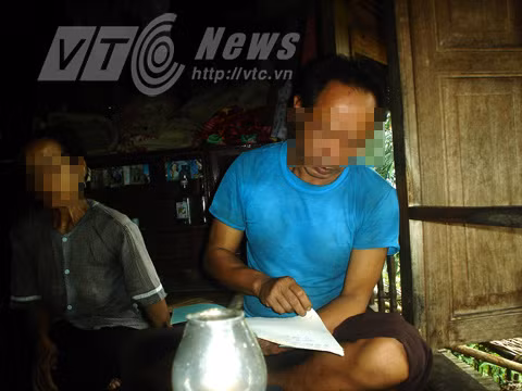 Ông Hà Văn M. đang đọc chú trong bài bùa "tơm thăm" cho phóng viên nghe.