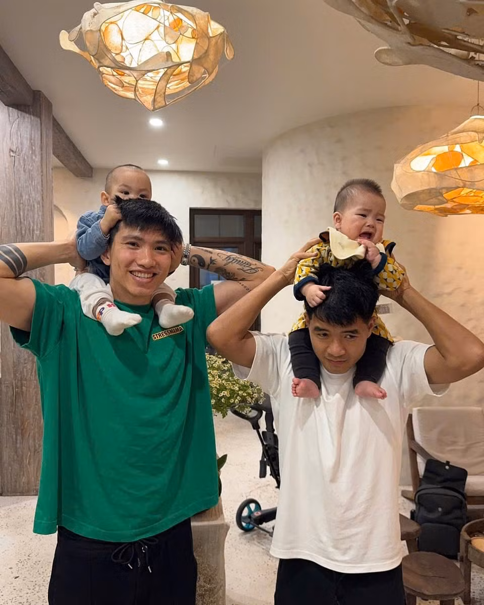 Hai bé - Lúa (con gái của Hà Đức Chinh và vợ Mai Hà Trang) và Phin (con trai của Đoàn Văn Hậu và vợ Doãn Hải My) - ngồi vững vàng trên vai cha, tạo nên khoảnh khắc gia đình ấm áp và đầy tình cảm.