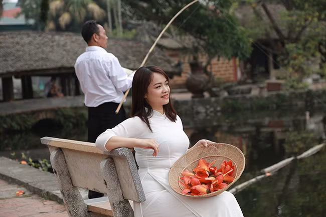 Cô gái tha thướt trong những tà áo dài trắng kết hợp với sắc đỏ của hoa gạo tạo nên những bức ảnh giản dị mà đẹp đẽ, có sức hút lạ kỳ. 