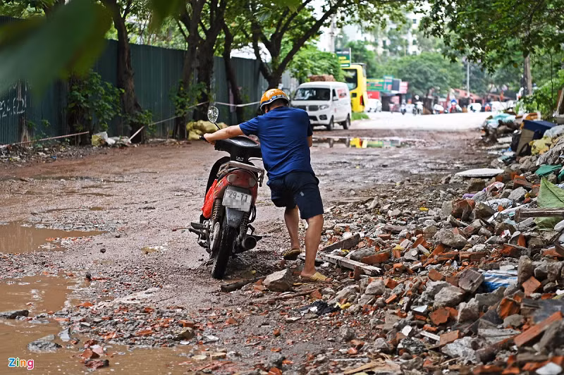 Mải tránh vũng nước giữa đường, người đàn ông tông trúng bãi phế thải ven đường khiến chiếc xe đổ ngang. Bà Hoài (ở phố Trương Công Giai) cho hay tình trạng người đi xe máy gặp tai nạn khi qua đây diễn ra thường xuyên. "Nhất là vào buổi tối, người đâm vào bãi rác hay vũng nước ngày nào cũng diễn ra", bà Hoài nói.