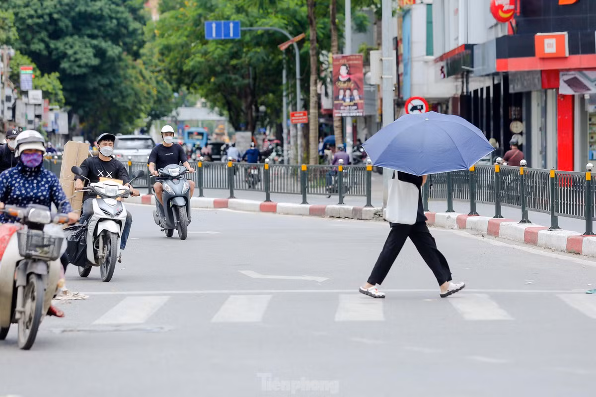 Người đi bộ mang theo ô chống nắng.