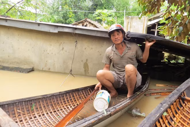Nước lên nhanh, khiến nhiều hộ dân bị ngập sâu do lũ lụt ở Phú Yên, bà con phải dùng thuyền di dời các vật dụng gia đình lên các vùng cao hơn. Ảnh: La Hai. 
