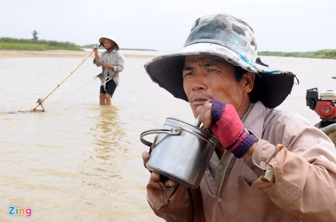 Người dân tranh thủ ăn trưa (cơm nấu ở nhà mang theo) ngay trên ghe máy neo giữa sông để tiếp tục công việc.