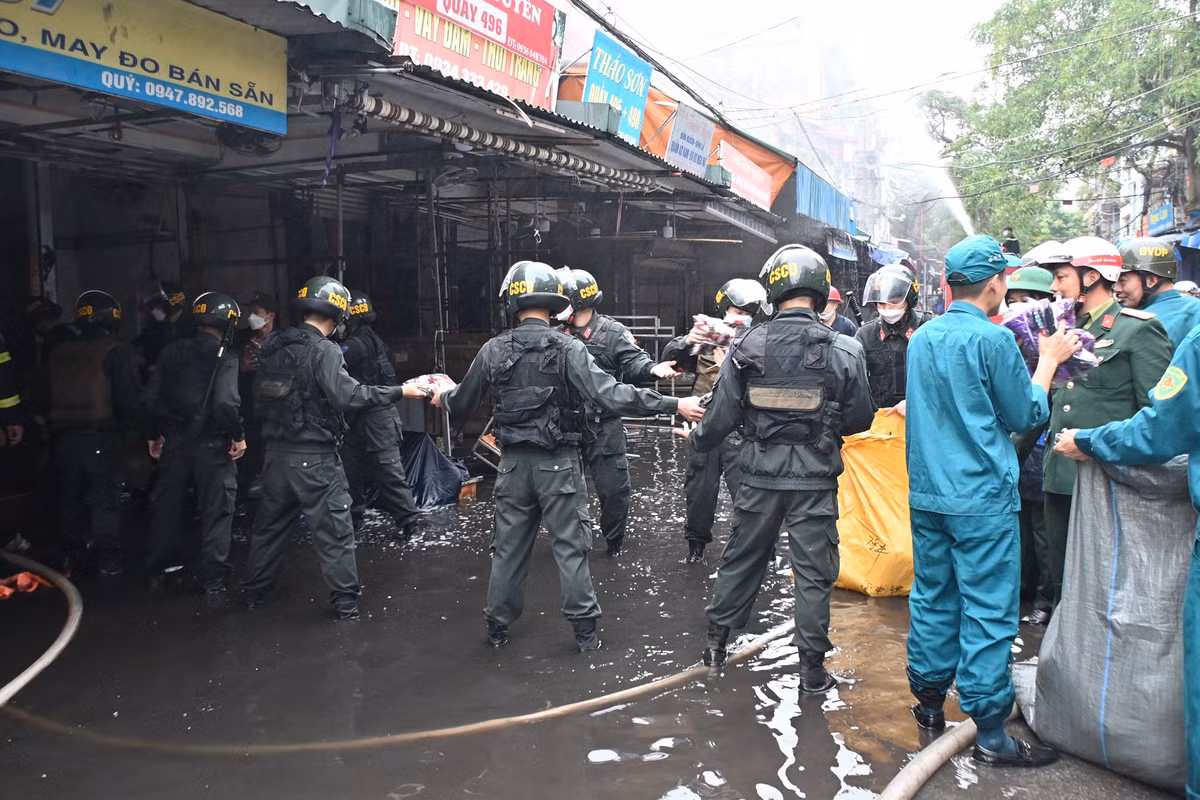 Nhiều hàng hóa được cứu hộ di chuyển ra khỏi khu vực cháy.