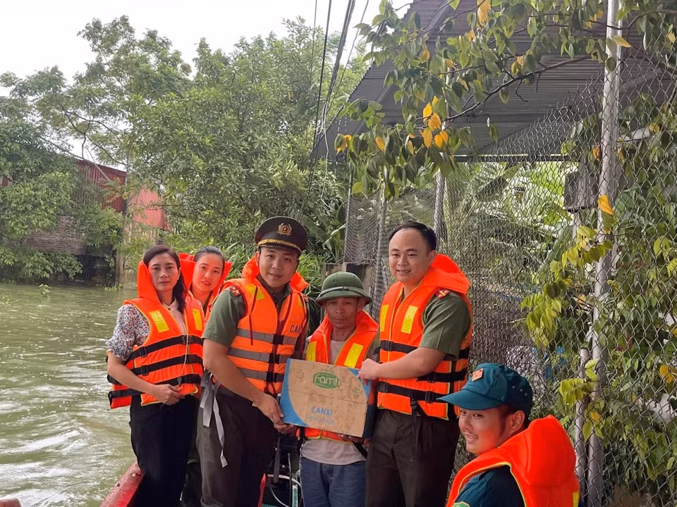 Lực lượng công an bơi thuyền vào "rốn lũ" tiếp tế mì tôm, sữa, nước uống... cho bà con nhân dân. 
