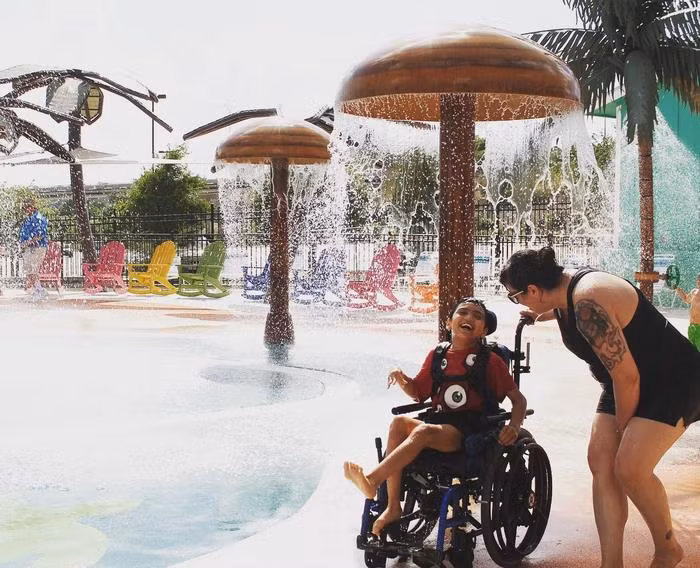 Hai mẹ con một em bé vui đùa thoải mái ngay cả khi ngồi trên xe lăn.