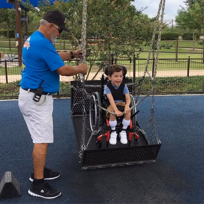 Nụ cười rạng rỡ của một cậu bé bị khuyết tật ở chân khi được thả lỏng chơi xích đu như những người bạn khác.