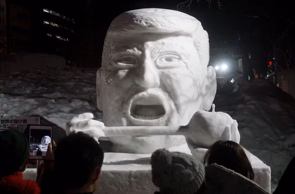 Du khách chụp ảnh tượng điêu khắc Tổng thống Mỹ Donald Trump bằng băng tuyết tại lễ hội tuyết Sapporo ở Sapporo, Nhật Bản, ngày 10/2/2017.