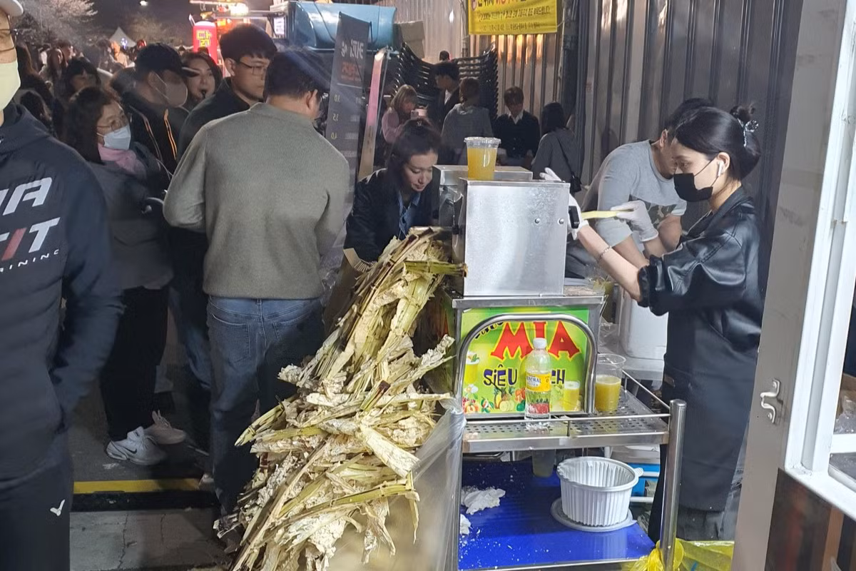 Đáng ngạc nhiên, xe nước mía thu hút một lượng khách đông nghịt xếp hàng chờ mua, khiến người bán không cả kịp dọn bã. Ảnh: Vietnamnet