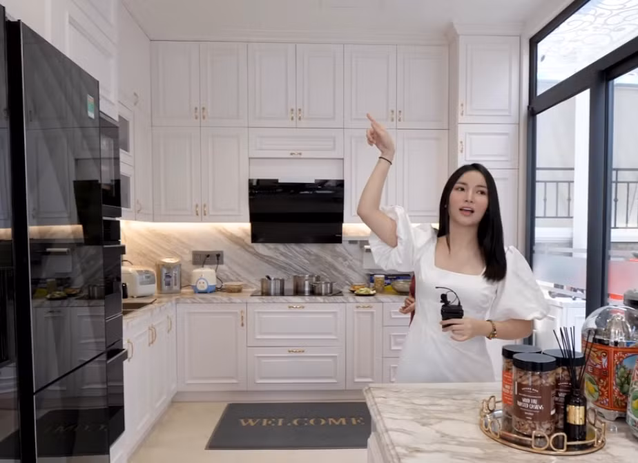 Khu bếp sử dụng gam màu trắng chủ đạo với hệ tủ kịch trần hiện đại.