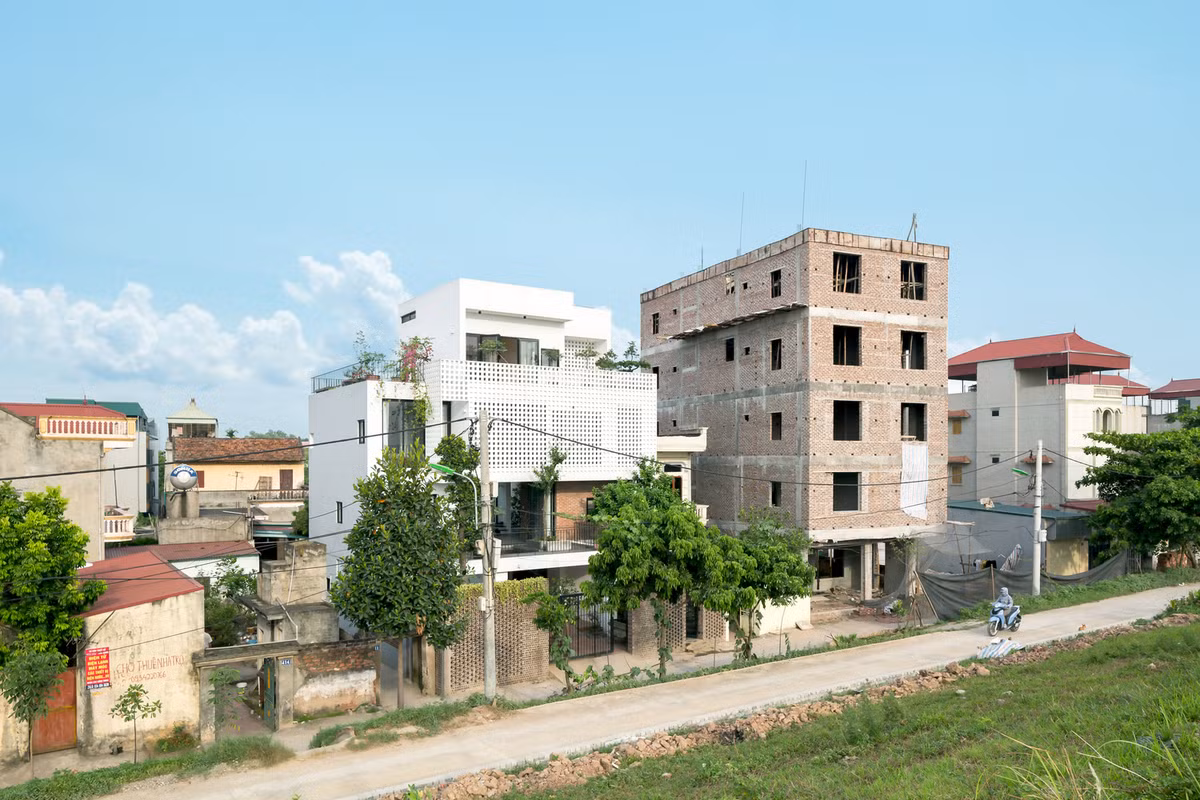 Nằm ngay chân đê sông Đáy, phường Yên Nghĩa (quận Hà Đông, Hà Nội), ngôi nhà mở ra một góc nhìn 40 độ lên mặt đường chính triền đê với ba cao độ mặt đường hạ cấp xuống nền công trình.