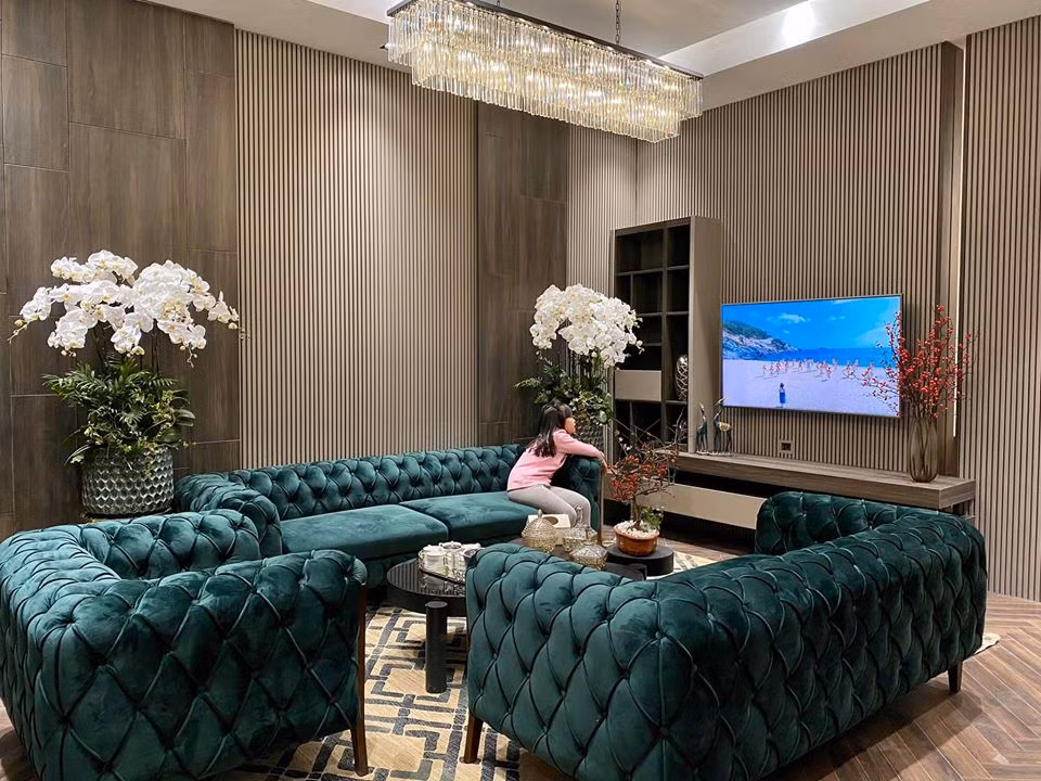 Không gian phòng khách rộng rãi, nổi bật với bộ sofa màu xanh.