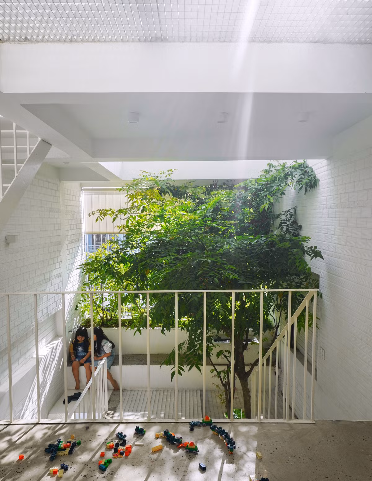 Cấu trúc căn nhà gắn với sân chơi ở phía trước mỗi tầng, mặt bằng chia làm 2 phần, 1/3 không gian phía sau là phòng ngủ, vệ sinh và bếp; 2/3 không gian phía trước là sân chơi đa năng, chỗ học, với ánh sáng tự nhiên và cây xanh.