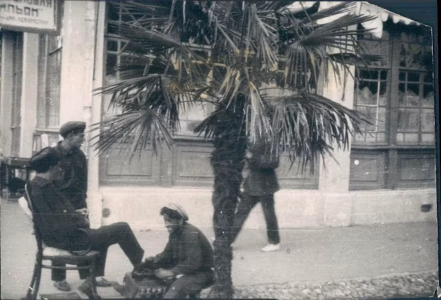 Thợ đánh giày cẩn thận đánh sáng bóng đôi giày cho khách tại Batumi năm 1928.