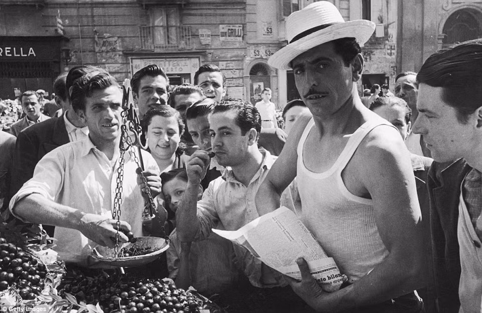 Không chỉ có phụ nữ bán hàng, ngay cả nam giới Italy cũng rất khéo léo khi bán trái cherry. Cửa hàng bán cherry của người đàn ông này khá đắt hàng khi hàng dài khách cả nam lẫn nữ chờ mua hàng. Ảnh chụp tại Naples, Italy năm 1952.