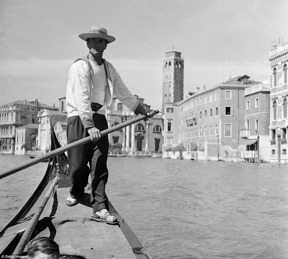 Người chèo thuyền chở khách ngắm cảnh đẹp Venice qua các kênh. Du khách có cơ hội ngắm cảnh thành phố xinh đẹp này bằng cách thuê thuyền đi dạo trên kênh. Ảnh chụp tại Italy vào khoảng năm 1950.