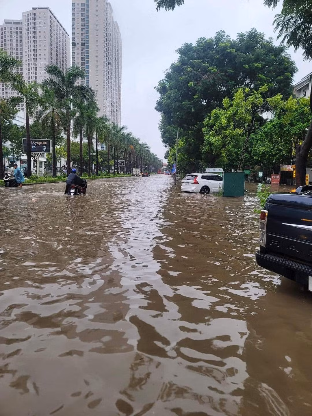 Nước ngập khiến người dân không thể phân biệt được đâu là đường, đâu là vỉa hè, nhiều người đã chọn dắt xe qua những chỗ ngập sâu để tránh tình trạng xe chết máy.