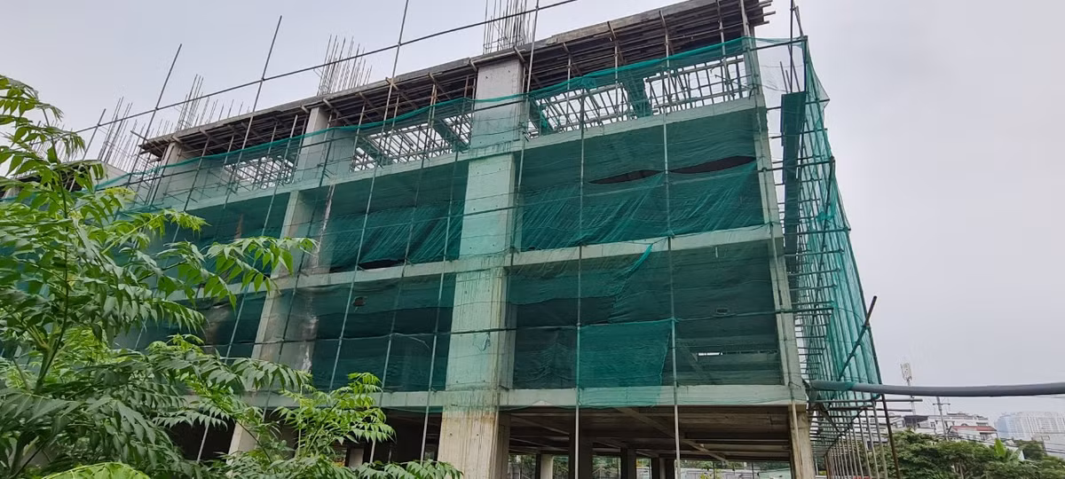 Khối nhà dự kiến cao hơn chục tầng đang xây dựng dang dở thì tạm dừng. 