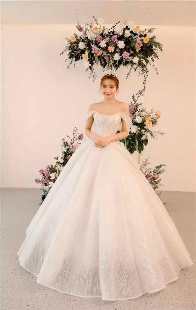 Mẫu váy cuối cho đám cưới Đồng Tháp có đuôi váy xếp tầng, phom dáng công chúa với tay trễ và đính kết nhẹ nhàng.