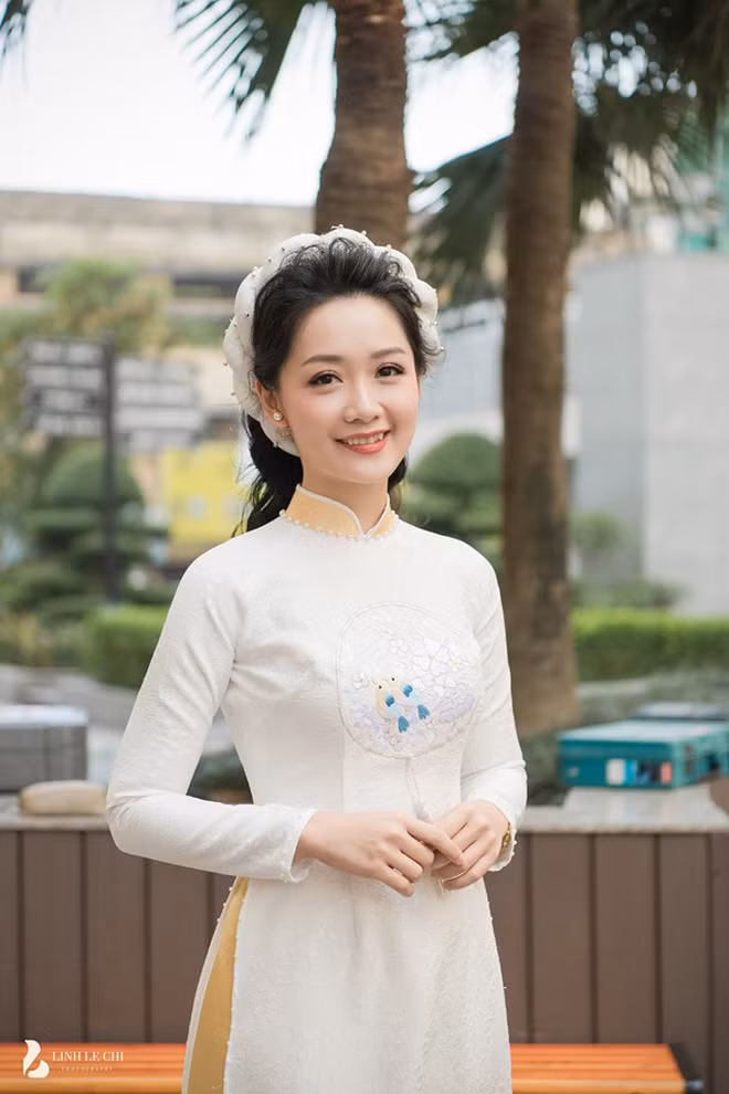 Trong lễ ăn hỏi của mình, Thu Hà diện mẫu áo dài trắng với chiếc mấn cách tân.