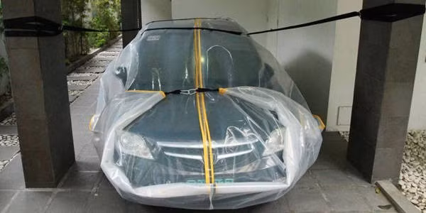Bọc ô tô và chằng buộc trước khi bão đổ bộ.